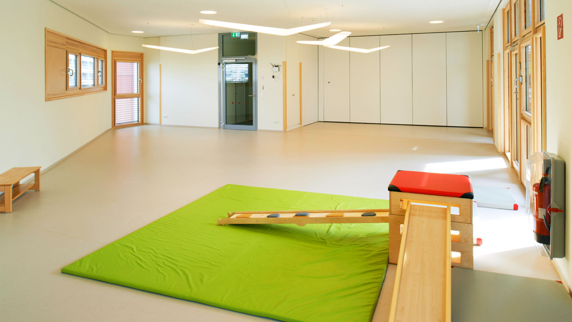 Große Turnhalle der Kindertagesstätte, mit Klettermöglichkeiten und weichen Matten auf dem Boden