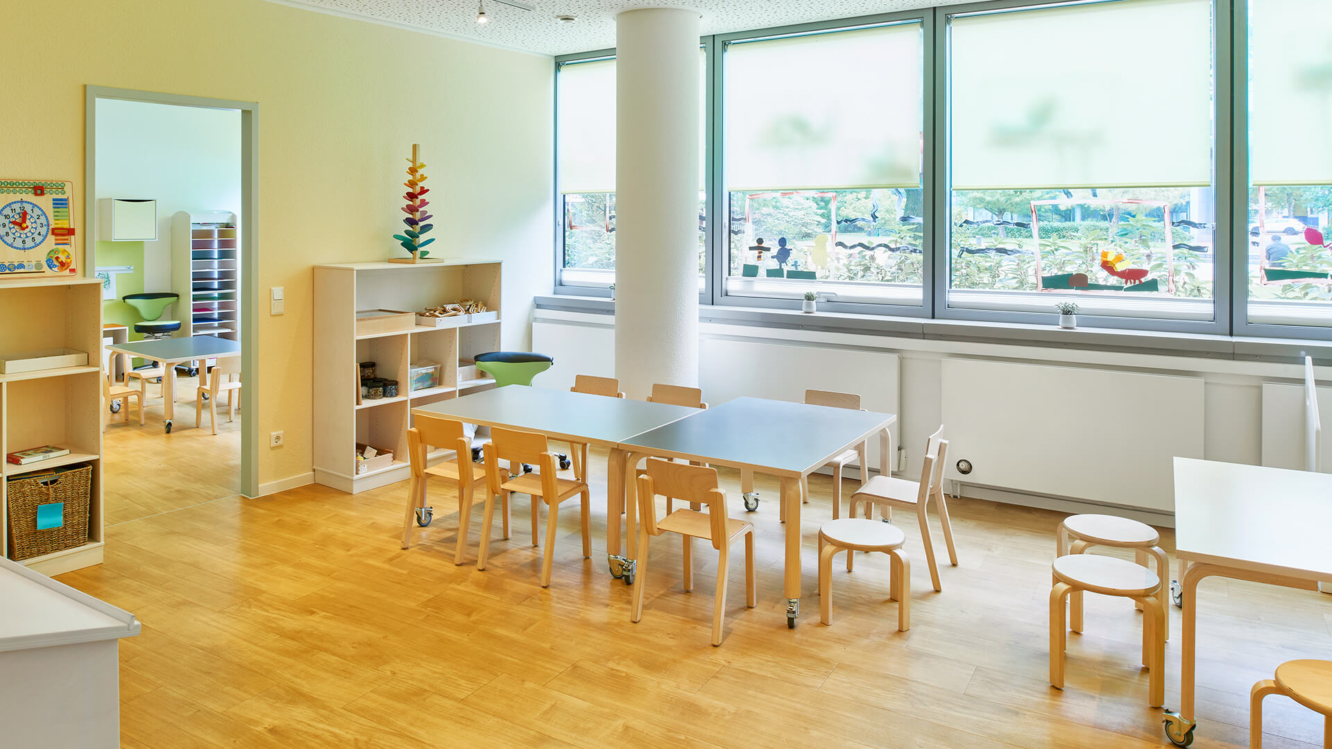 Große bemalte Fenster, Lern-Spielzeug und Tische mit Platz für viele Kinder